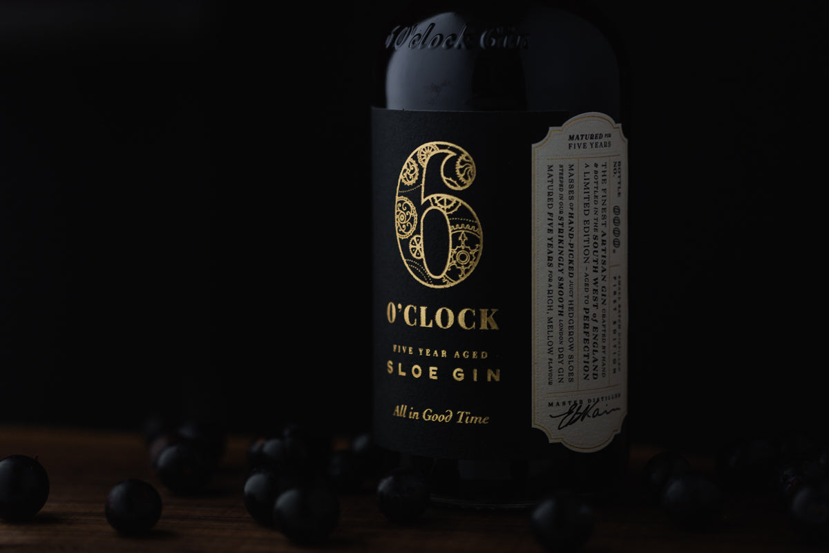 Bottle of Aged sloe gin surrounded by sloe berries